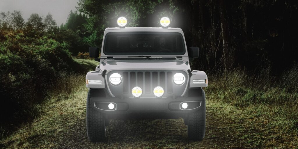 Truck with HELLA X-Treme Series LED Driving Lights in white mode with X-shape position light, IP69K, auxiliary high-beam, roof rack and bumper mounted for off-road adventure.
