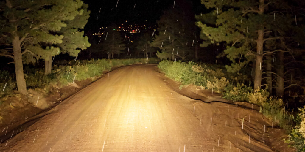 HELLA X-Treme Series LED Driving Lights in white mode with X-shape position light, IP69K, illuminating off-road trail as auxiliary high-beam.