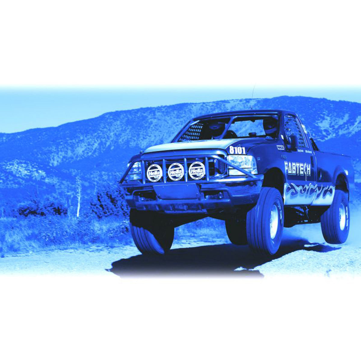 Blue off-road truck with three round HELLA 700 series spot lights mounted on a front bumper bar.
