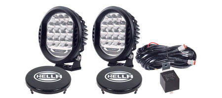 HELLA X-Treme Series LED Driving Lights in white mode with rugged IP69K aluminum housing, auxiliary high-beam, X-shape position light, off-road ready.