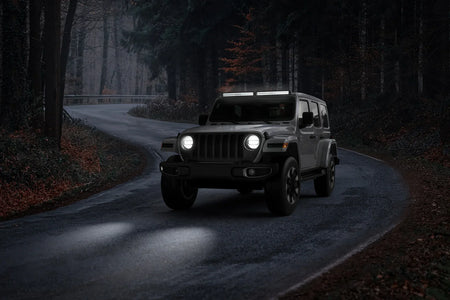 SUV with HELLA X-Treme Series LED Driving Lights in white mode, X-shape position light, IP69K, roof-mounted auxiliary high-beam for off-road adventure.