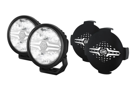 HELLA X-Treme Series LED Driving Lights in white mode with X-shape position light, IP69K auxiliary high-beam, rugged aluminum housing, clear lens.