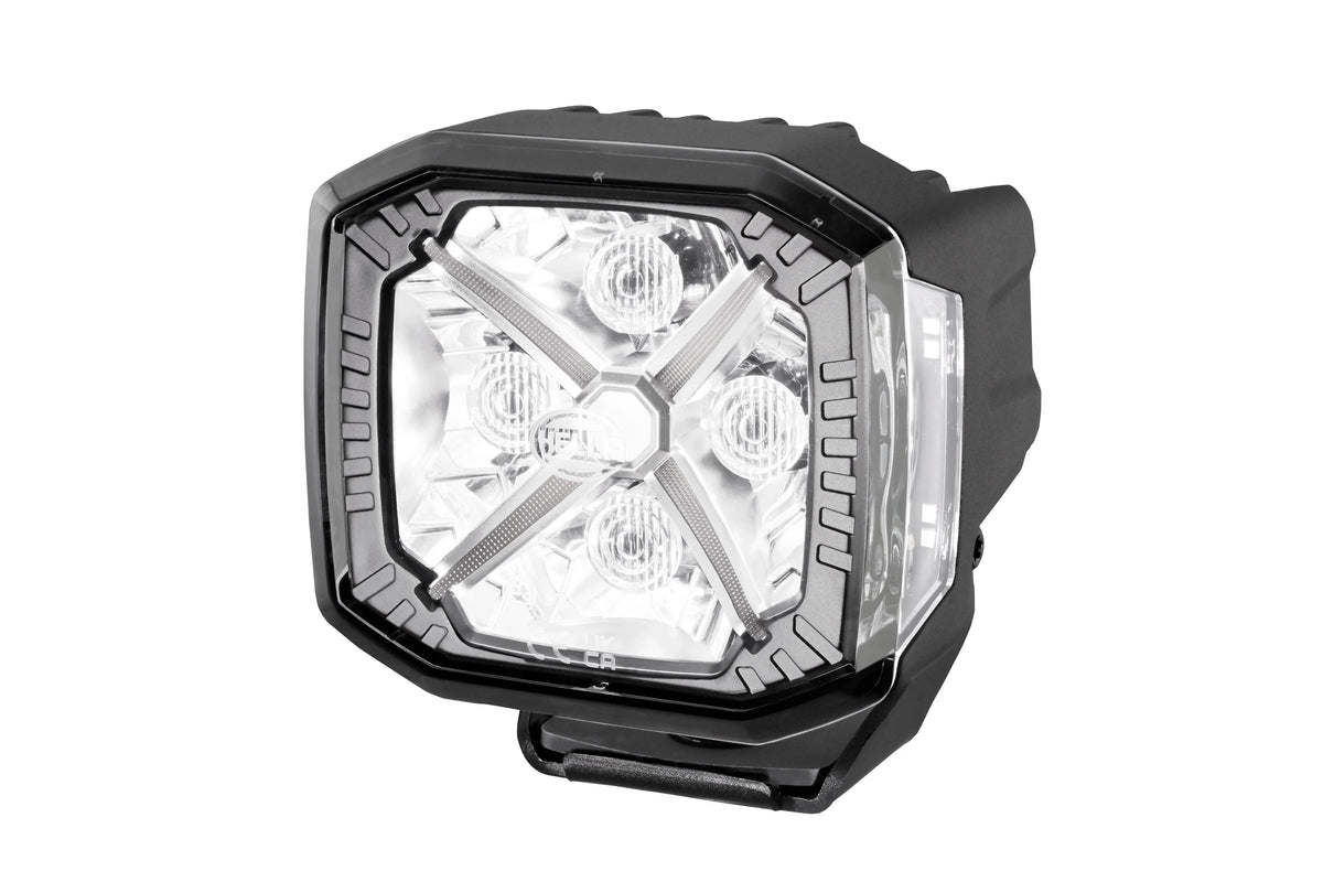 HELLA X-Treme Series LED Driving Lights in white mode with X-shape position light, rugged aluminum housing, IP69K, off-road auxiliary high-beam.