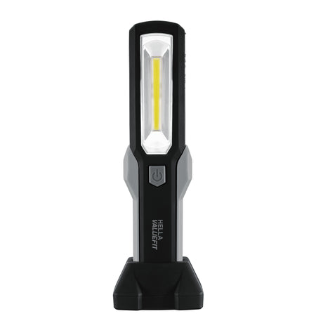 Black and gray HELLA VALUEFIT handheld work lamp with a rectangular LED light and power button, standing upright.
