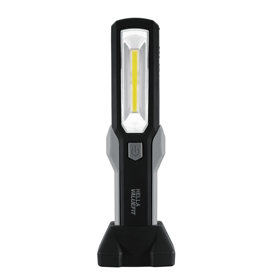 Black and gray HELLA VALUEFIT handheld work lamp with a rectangular LED light and power button, standing upright.